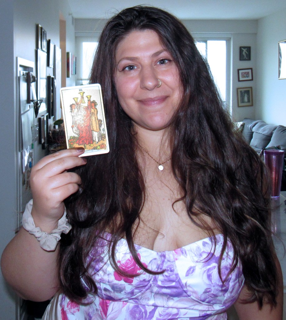 Image of the author of the post holding a tarot card